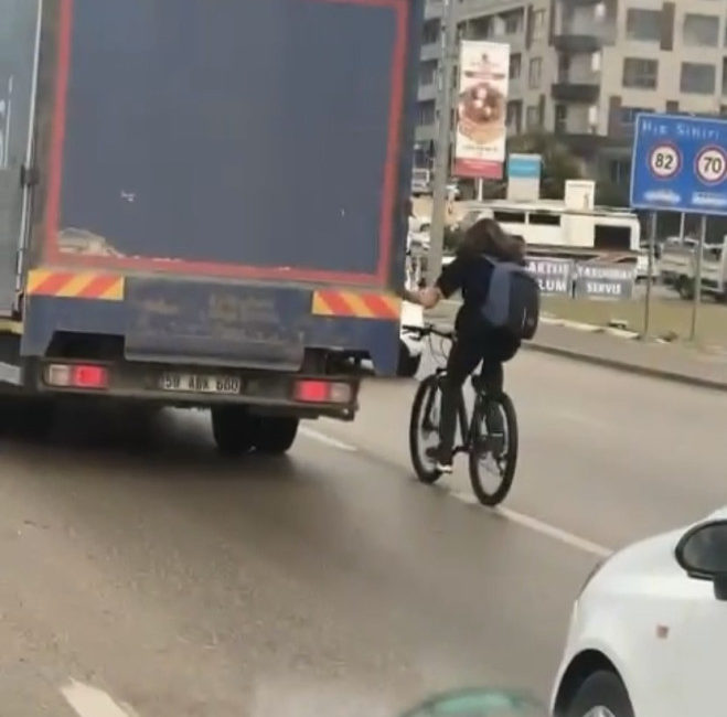 Bursa'nın Nilüfer ilçesinde, rüzgarı engellemek için kamyonetin arkasından tutunarak giden