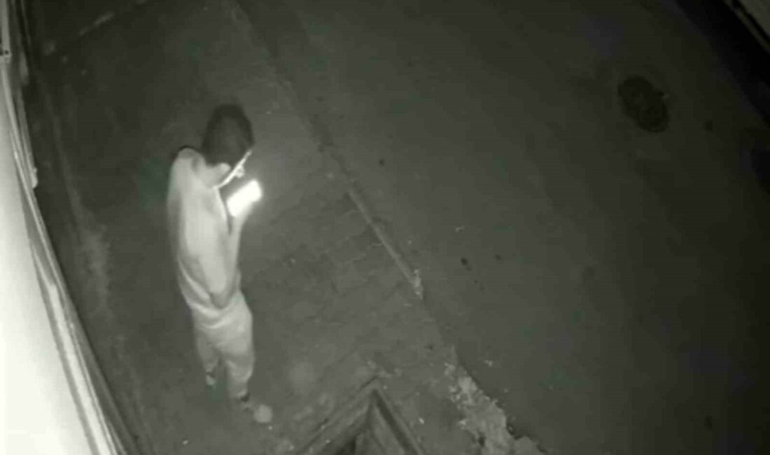 BURSA'DA BİR SİTENİN ÖNÜNDE CEP TELEFONUNA BAKARAK YÜRÜYEN GENÇ, KAPAĞI