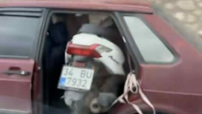 Bursa’da bir sürücü kapısız trafiğe çıktığı otomobille motosiklet taşıdı. Görenleri