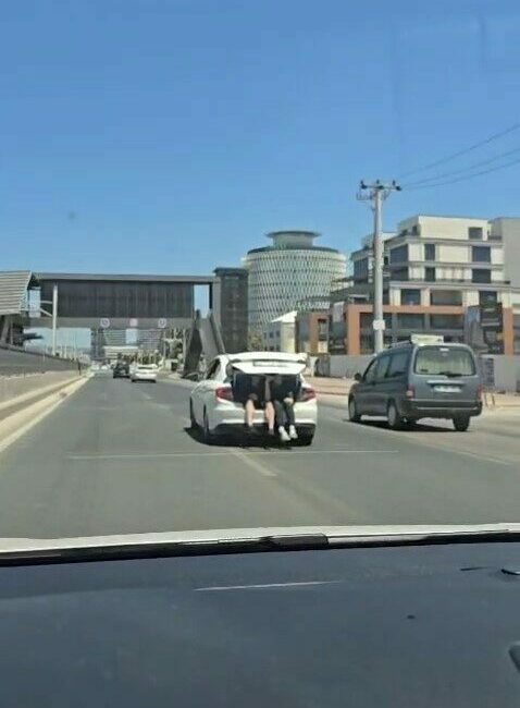 Kilometrelerce bagajda seyahat ettiler Bursa’da sedan bir otomobilin bagajında kapısı açık halde yolculuk yapan