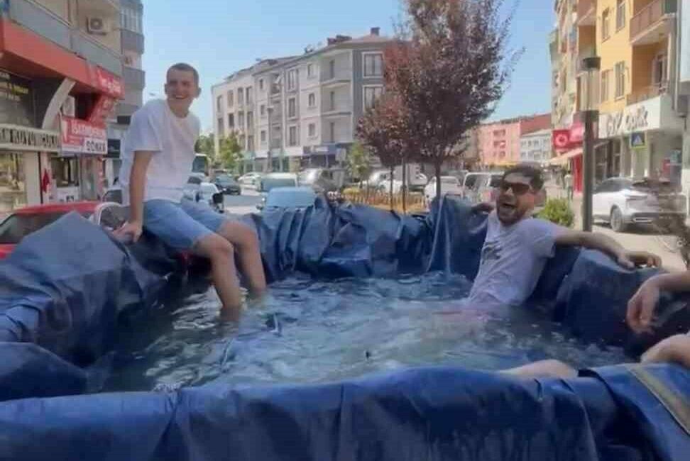 Bursa’da sıcak havalardan bunalan bir grup genç, traktörün römorkunu suyla