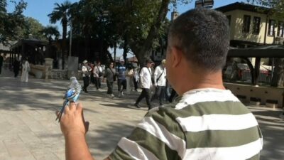 Bursa’da sahibinin omzunda ve elinde kapalı çarşıyı dolaşan muhabbet kuşu,