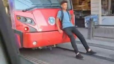 Bursa’da, seyir halindeki tramvayın arkasına oturarak yolculuk yapan bir çocuk