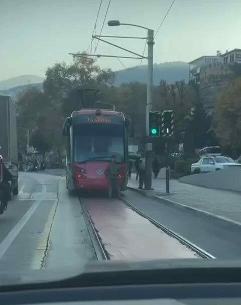 Bursa’nın Osmangazi ilçesinde seyir halindeki tramvayın arkasına oturarak yolculuk yapan