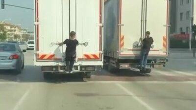 Bursa’da seyir halindeki kamyonların arkasına tutunarak yolculuk yapan gençler, hem